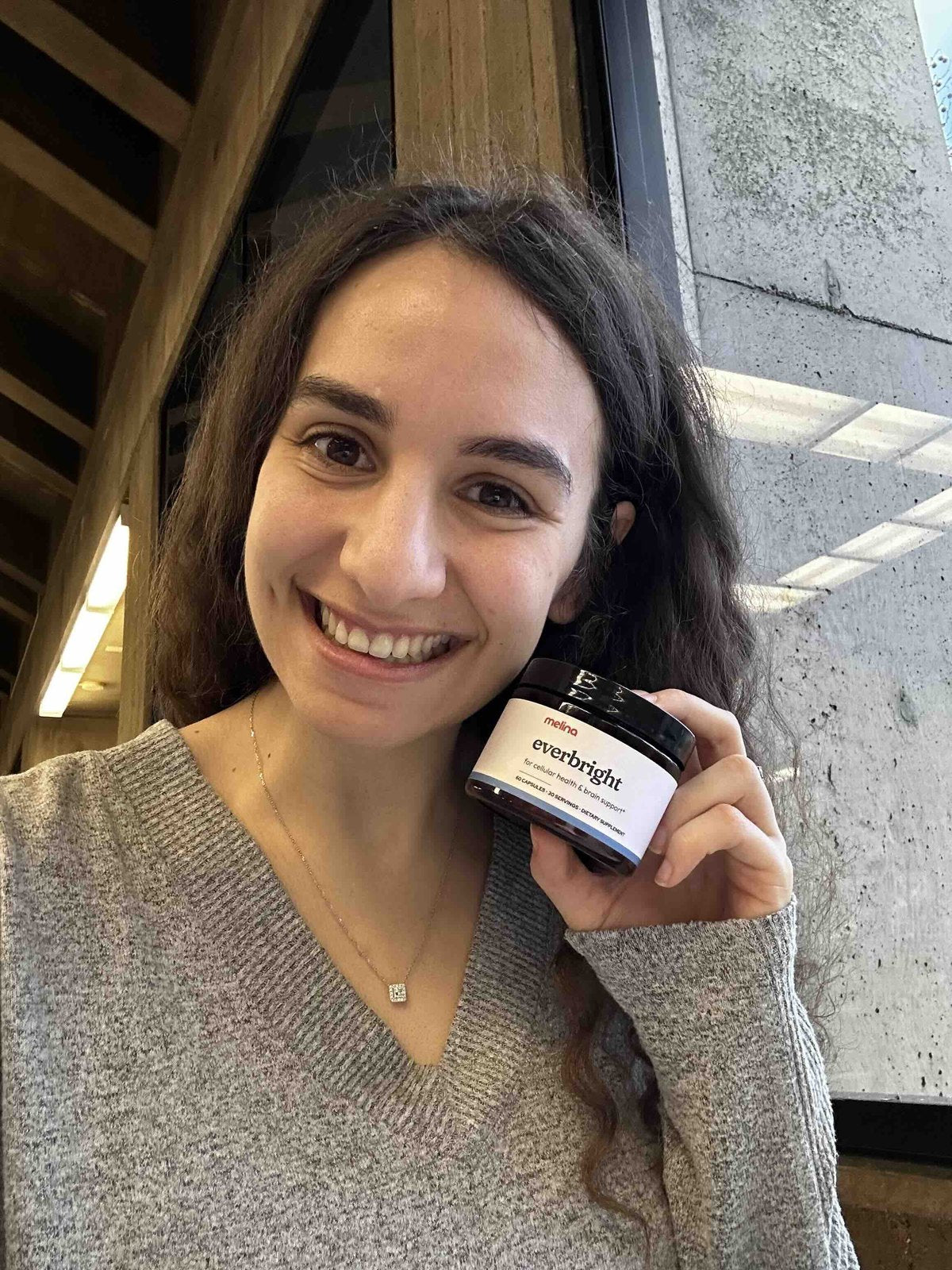 Laila smiling, holding a jar of Everbright